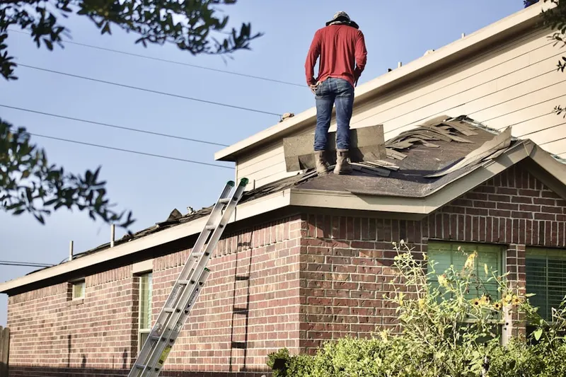 Professional roofer working on a residential roof in Blanco